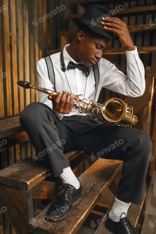 Preview: Black jazz musician sitting with saxophone