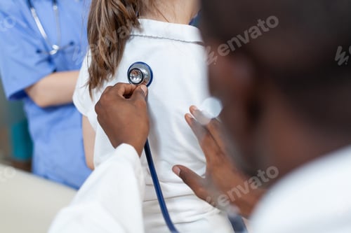 Preview: Closeup of african american pediatrician doctor examining lungs of young girl