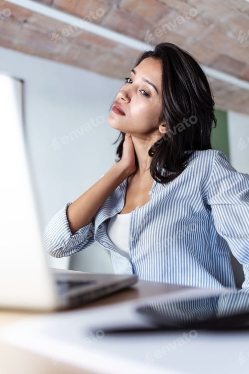 Preview: Tired young business woman taking a moment for relax while working with her laptop in the office.