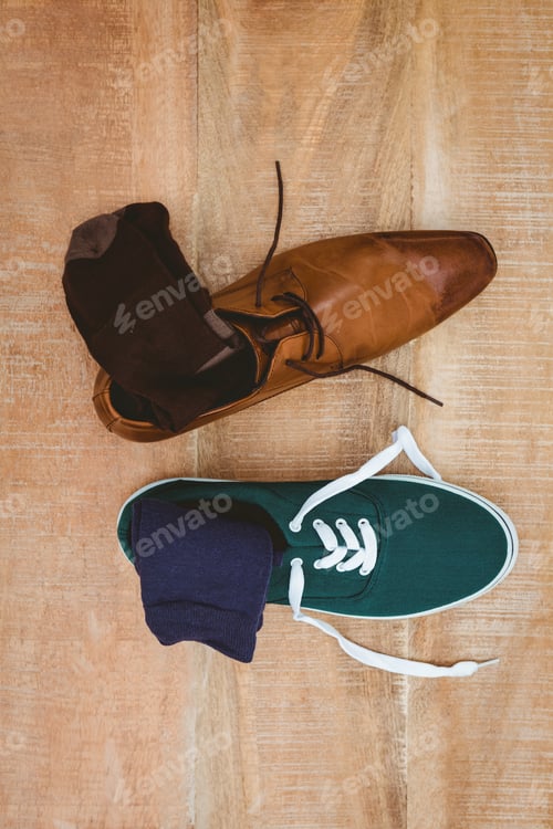 Preview: View of two different shoes on wood plank