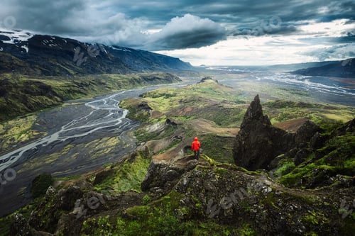 Preview: Hiker man in red jacket standing on top of Valahnukur surrounded by volcanic mountain at Thorsmork