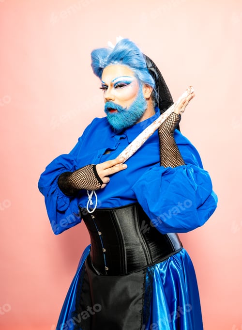 Preview: Flamboyant Drag Queen in Blue Attire Holding a Salami Sausage