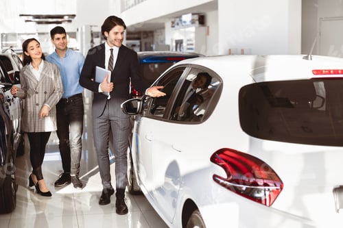 Preview: Dealer Showing Young Family New Auto In Dealership Store
