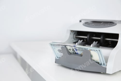 Preview: Counting machine with money on white table. Space for text