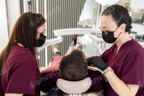Preview: Dentists work together on a patient in a dental clinic during a routine checkup