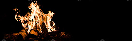 Preview: panoramic shot of logs burning in camp fire in darkness