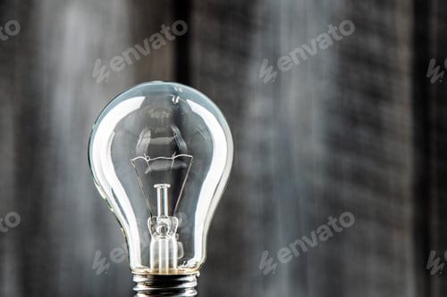 Preview: Clear Lightbulb Against Blurred Textured Gray Background