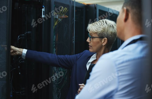 Preview: Shot of two workers inspecting the electronic equipment in a server room together at work