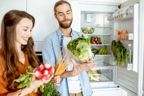 Preview: Vegan couple with fresh vegatables at the kitchen
