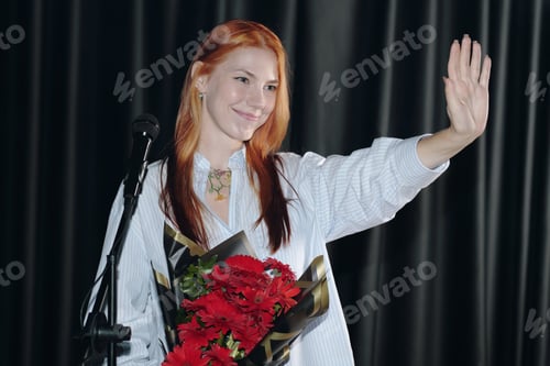 Preview: Waving Girl Holding Bouquet of Red Flowers on Stage