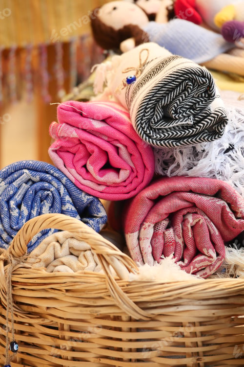 Preview: Handmade textiles and dolls in a woven basket at a craft fair