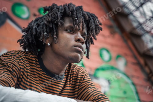Preview: Portrait of young handsome stylish black man with natural hair dreadlocks. Afroamerican guy. Stairs,