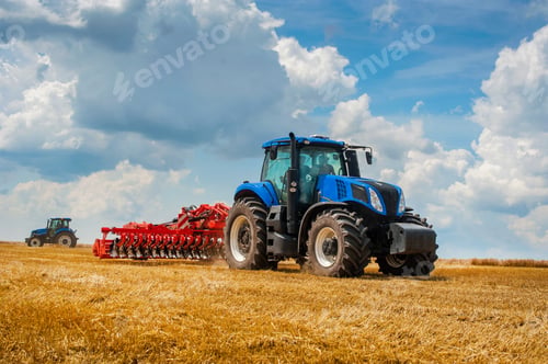 Preview: new blue tractor in motion at demonstration field site at working with harrows.