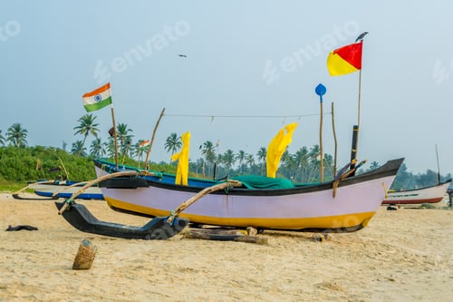 Preview: old fishing boats in sand on ocean in India on blue sky background