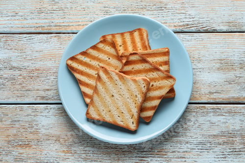 Preview: Plate with slices of delicious toasted bread on wooden table, top view