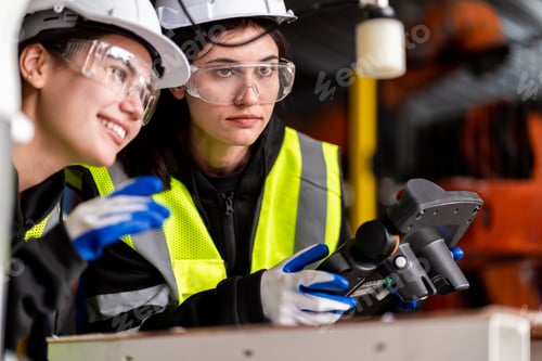 Preview: A team engineers meeting to inspect computer-controlled steel welding robots.