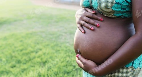 Preview: Close up pregnant belly of young African woman in park - Maternity lifestyle concept