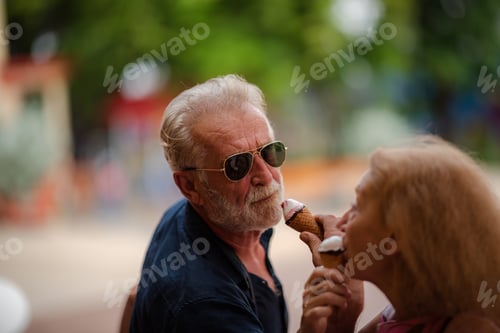 Preview: elderly senior couple woman and man having fun and happy together at amusement them park