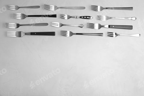 Preview: Flat lay composition with different forks on grey table, space for text
