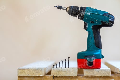 Preview: Electric cordless screwdriver and some screws close-up
