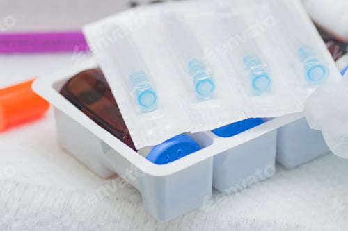 Preview: Medical bottles and ampoules with syringe needles in a pack. Injection procedures equipment