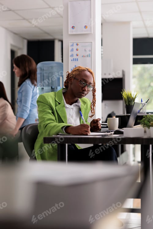 Preview: Employee in coworking open space, writing on clipboard