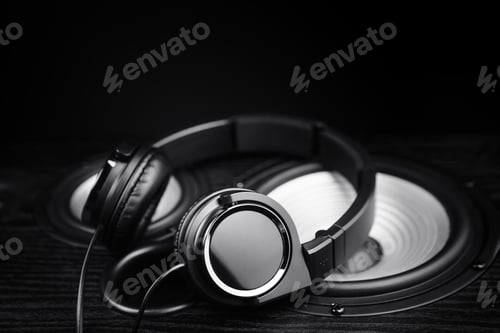 Preview: Photo of black headphones on music audio speaker. Close-up.