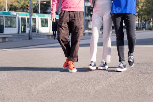 Preview: legs of three friends walking on a sunny day