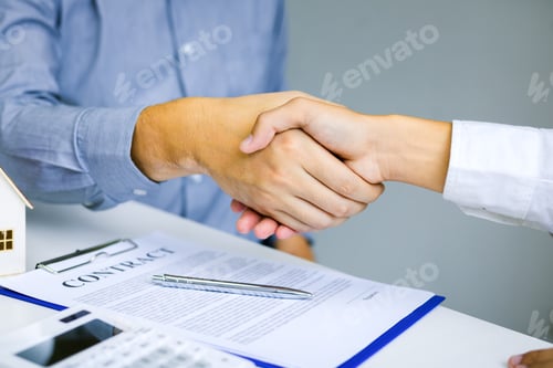 Preview: shaking hands with customer and real estate broker after signing a contract