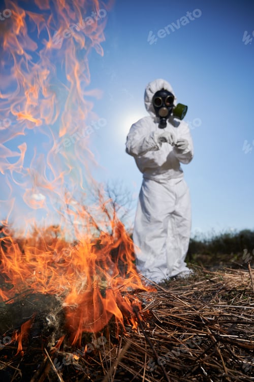 Preview: Unrecognizable person burning old dried grass in field