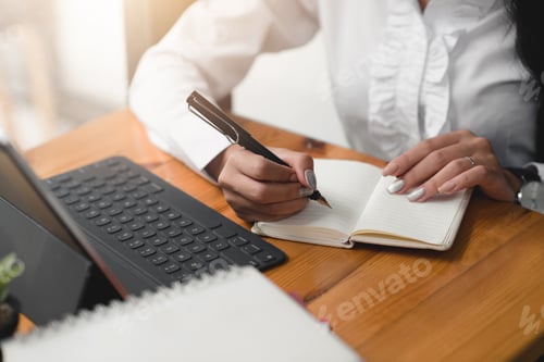 Preview: Business woman take notes in notebook with laptop in office.