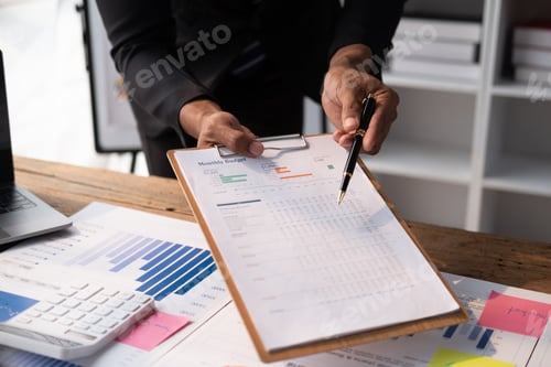 Preview: Close up view of young smart businessman analysing the investment strategy in office room.