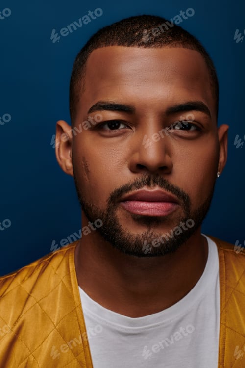 Preview: portrait of young bearded man with diamond earring looking straight at camera, fashion concept