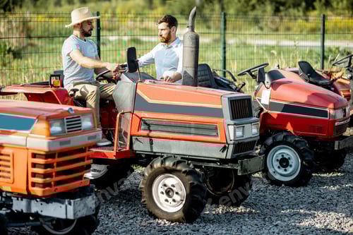 Preview: Men Riding Tractors on Gravel in Rural Setting
