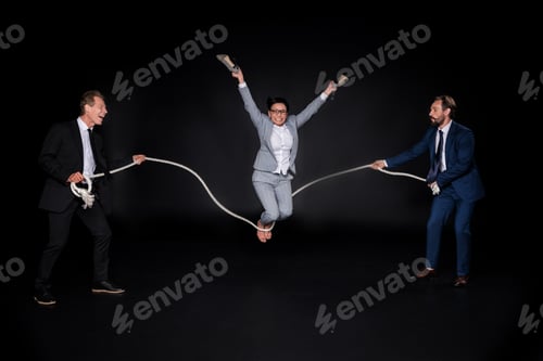 Preview: businessmen holding rope while mature barefoot asian businesswoman jumping isolated on black