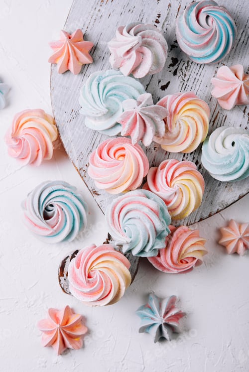 Preview: Multicolored meringue on wooden tray top view