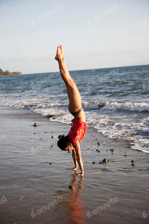 Preview: Handstand on a sunny beach shore.