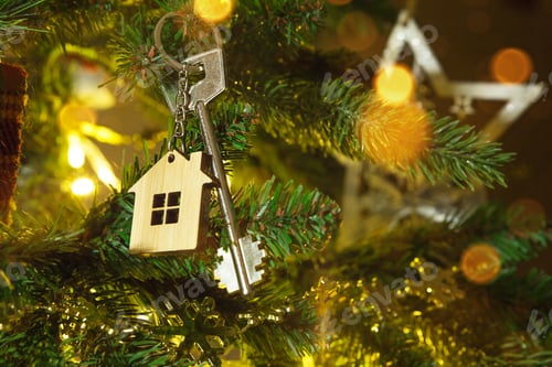 Preview: Key to the house with a keychain is hanging on the Christmas tree. A gift for New Year, Christmas.