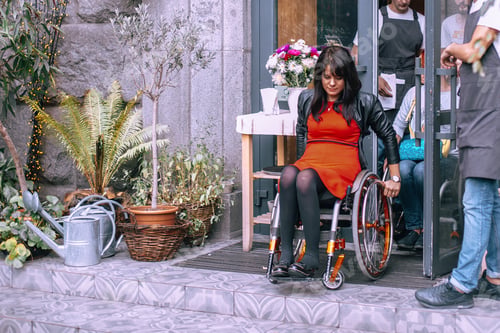 Preview: The waiter opens the door to a girl on a wheelchair in a city cafe