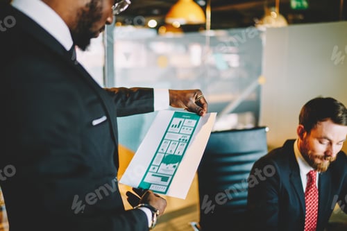 Preview: Black businessman checking graph in office