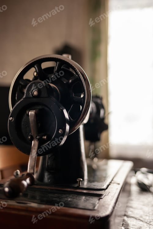 Preview: Old sewing machine stands on the table at home ready to work and sew.