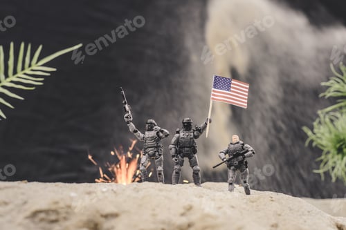 Preview: selective focus of toy soldiers with guns and american flag standing near explosion on sand dune