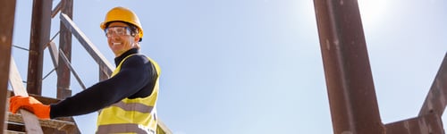 Preview: Cheerful male engineer standing on stairs outdoors