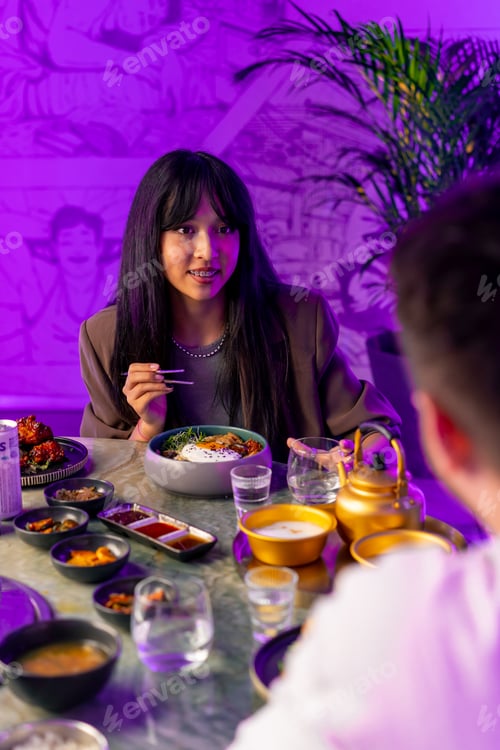 Preview: girl enjoying traditional Korean cuisine with chopsticks in a restaurant with a boyfriend on a date