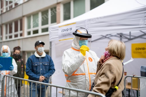 Preview: People waiting in covid-19 testing center outdoors on street, coronavirus concept.