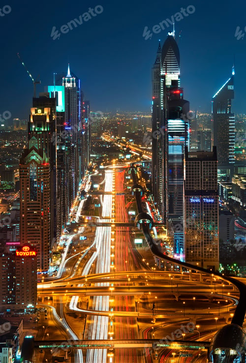 Preview: Cityscape with skyscrapers and illuminated road in Dubai, United Arab Emirates at dusk.