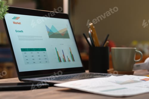 Preview: laptop with paperwork on wood table in living room at home.work at home