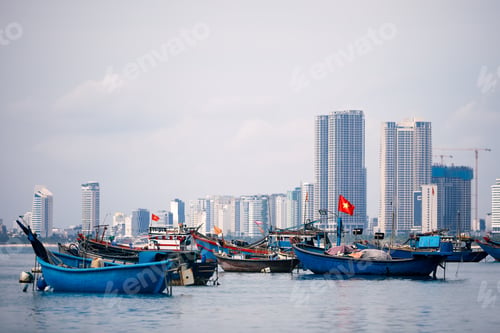 Preview: Vietnamese flag on fishing boat moored against urban skyline