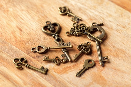 Preview: Collection of vintage brass keys scattered on a wooden surface