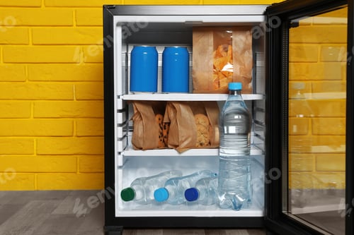 Preview: Mini bar filled with food and drinks near yellow brick wall indoors, closeup